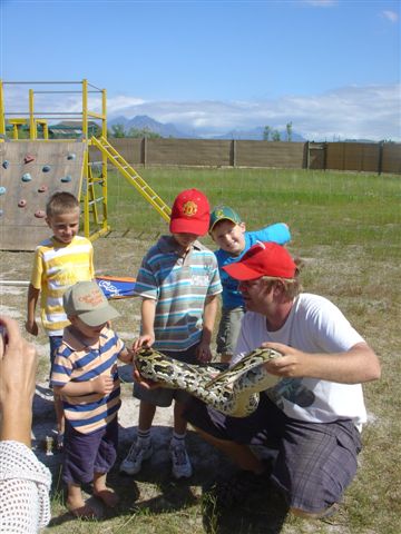 Children getting to know more about a python at Giraffe House, Cape Town